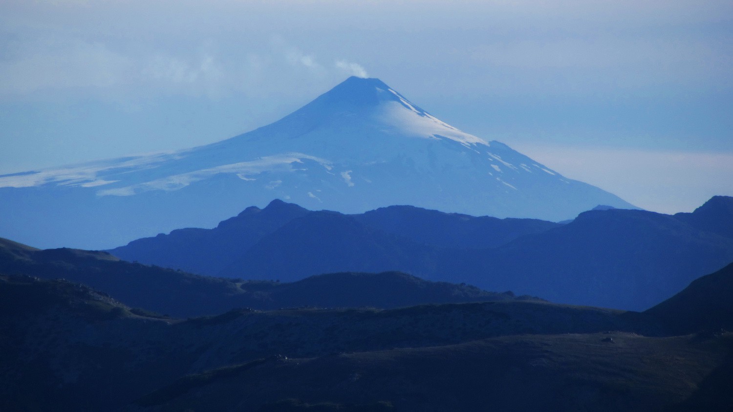 Smoking Volcan Villarrica seen from the summit of Cerro Moquehue